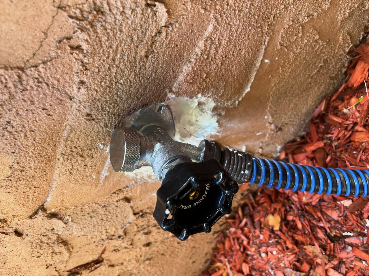 All-Plumb-Rooter plumber testing water pressure and running water outside client's home.